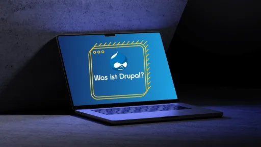 Laptop mit blauer Drupal-Webseite auf dem Bildschirm, beleuchtet in dunklem Raum.